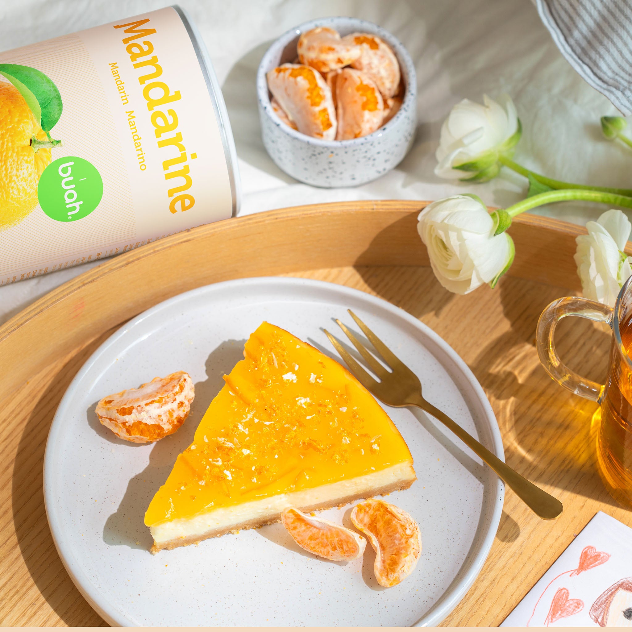 buah Mandarinen Stücke und ein Stück Mandarinenkuchen auf weißem Teller