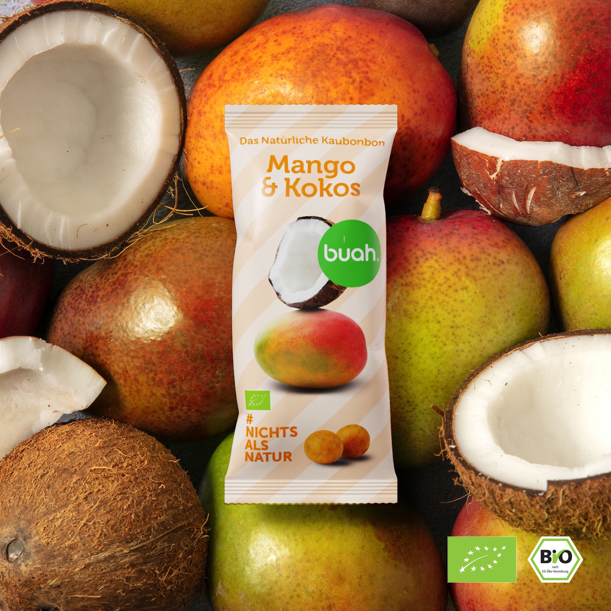 Buah Mango-Kokos Kaubonbon TĂĽte liegt auf frischen Kokosnuss und Mango