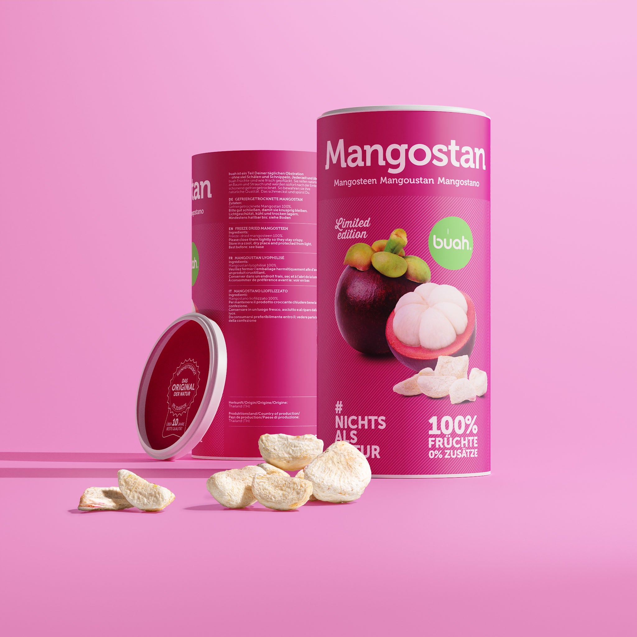 Eine Dose buah gefriergetrocknete Mangostan zeigt ihre RĂĽckseite mit den Zutaten. Der rote Deckel lehnt seitlich an der Dose. Davor liegen helle FruchtstĂĽcke auf einem pinken Hintergrund