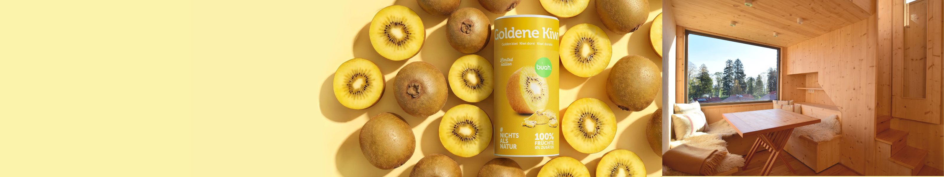 Ein breites Banner. Links steht eine Dose buah gefriergetrocknete Goldene Kiwi umgeben von frischen Kiwis auf gelbem Grund. Rechts sieht man das gemütliche, sonnendurchflutete Innere einer Holzhütte mit großem Fenster und Holztisch.