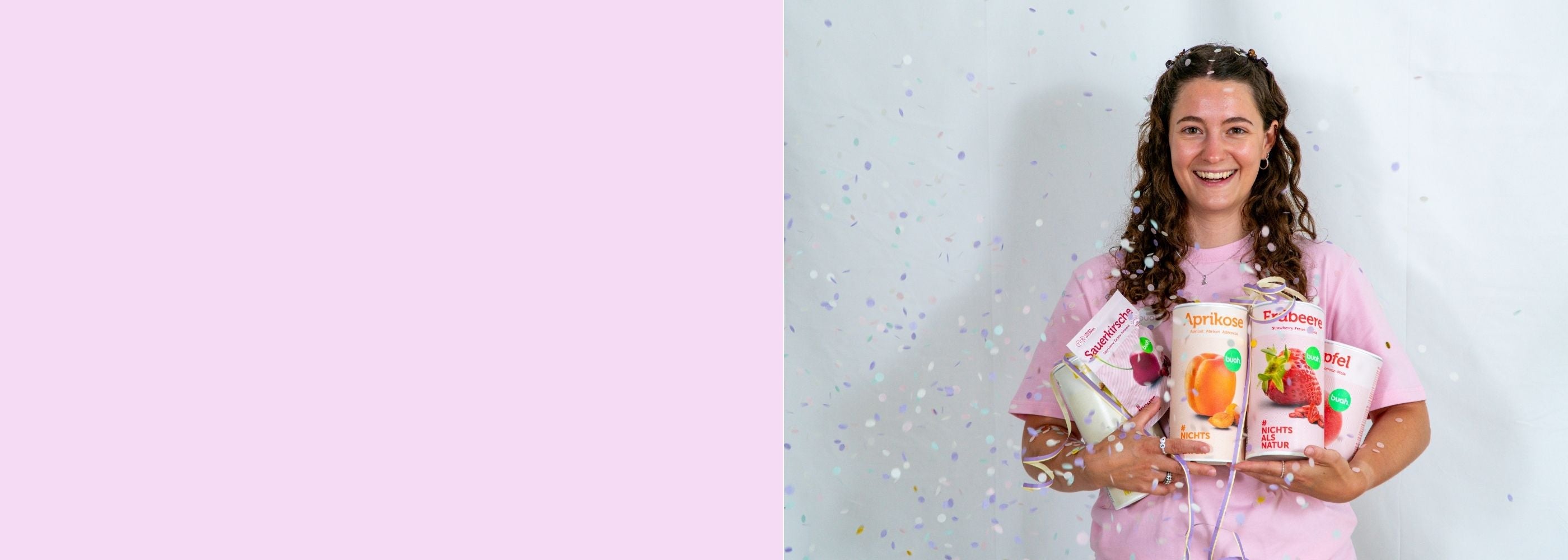 Vanessa von buah im rosa buah Shirt mit buah gefriergetrockneten Fruechten in der Dose im Arm - Konfetti und Luftschlangen vor rosa Hintergrund