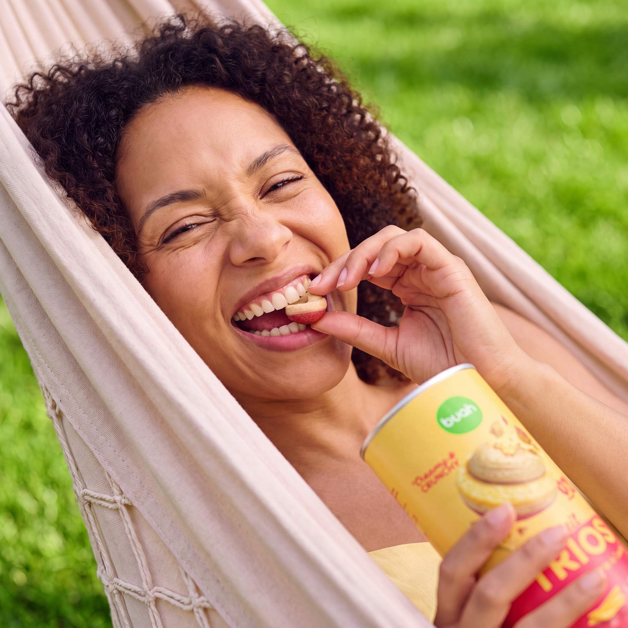 Neue Buah Trios Erdbeere, Mango & Cashew – Frau die in ein Trio beißt und sich freut