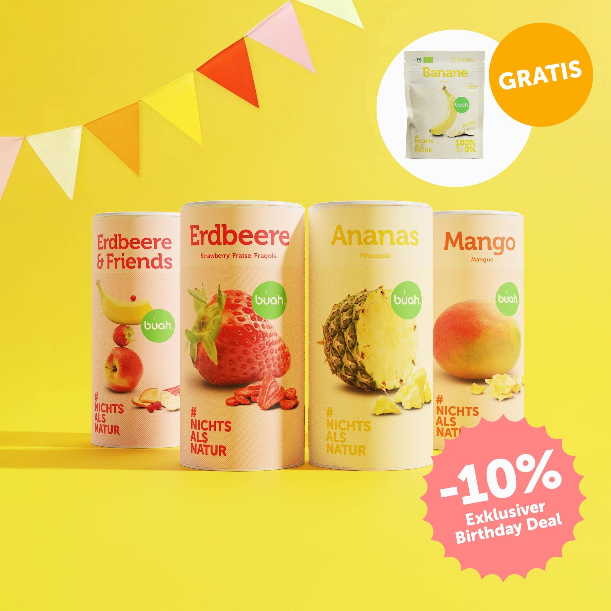 buah Birthday Set mit buah gefriergetrockneter Erdbeere, Ananas, Mango und Erdbeere & Friends vor gelbem Hintergrund mit bunten Girlanden im Hintergrund, 10% Badge im Bild und Banane Snackpack kostenlos