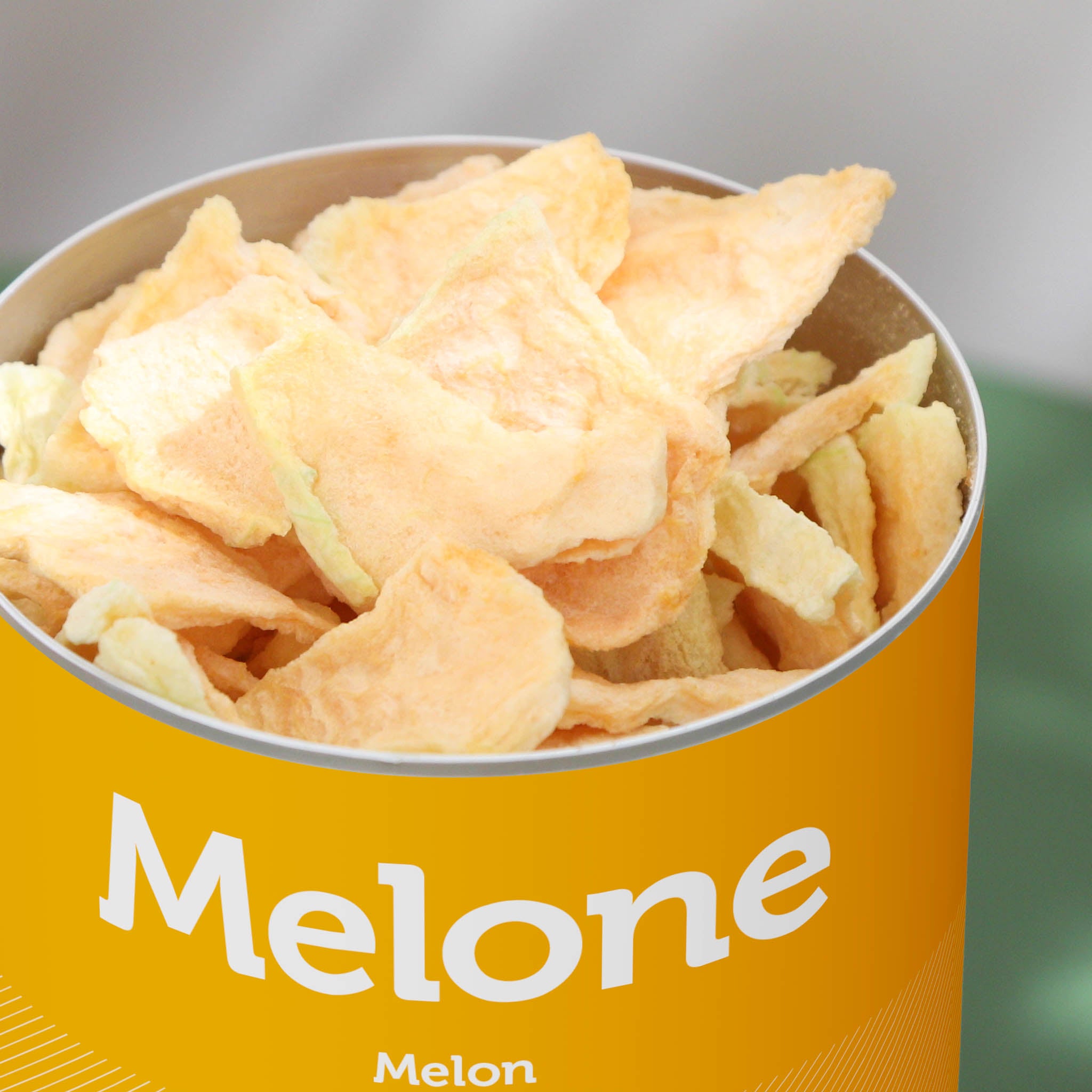 Nahaufnahme der buah gefriergetrockneten Dose Canatloupe Melone mit grossen Stuecken in heller Orange der Melone, die aus der Dose ragen. 