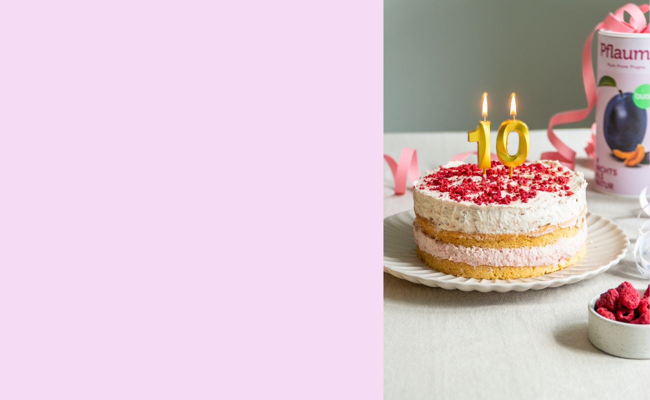 Split-Bild mit rosa Hintergrund und Bild der buah 10-Jahre Geburtstagstorte mit zwei Lagen und Creme mit buah Fruechten