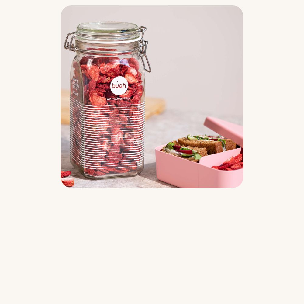 buah Glas Aufbewahrung mit Buegelverschluss voll mit buah gefriergetrockneter Erdbeere vor hellem Hintergrund