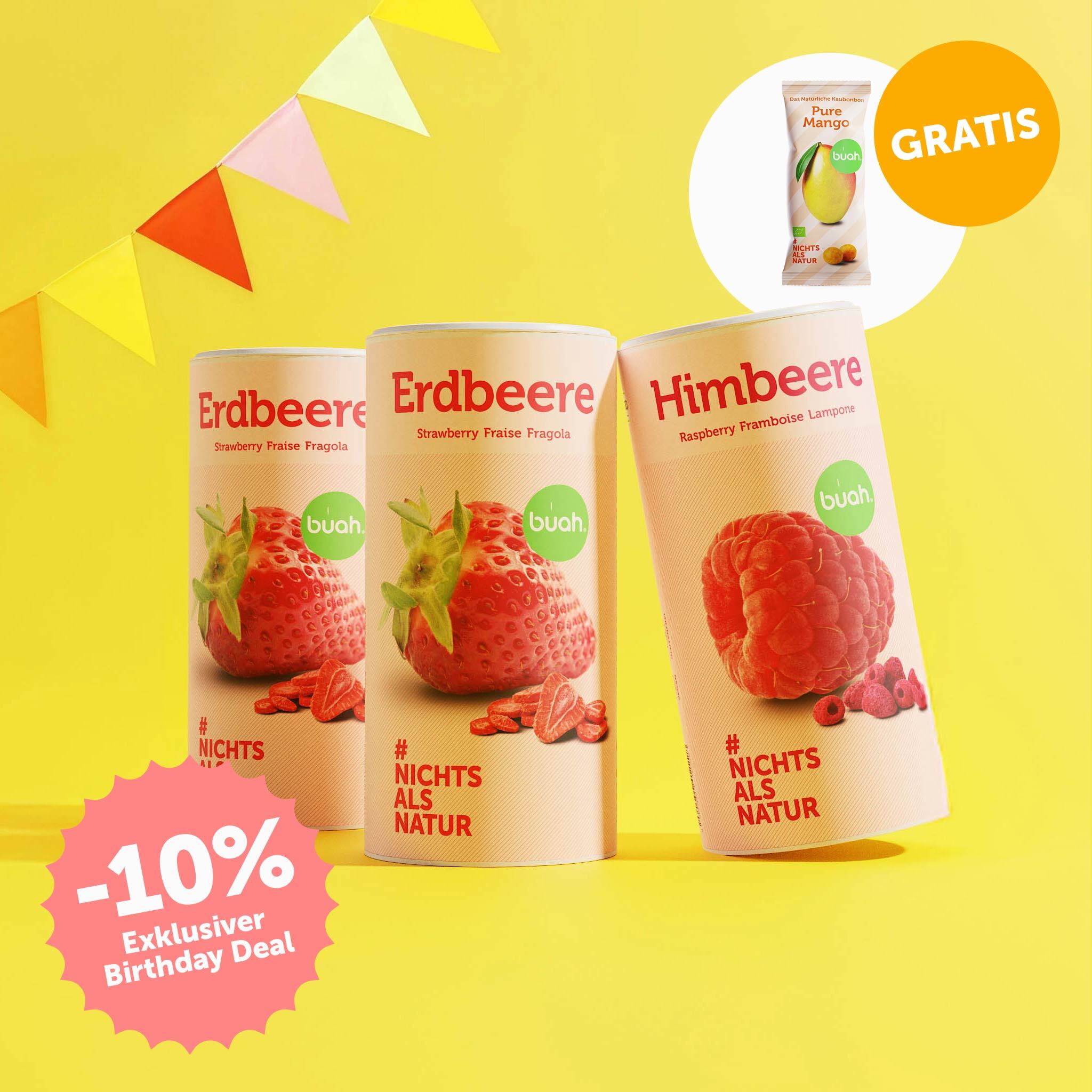 buah Birthday Set mit buah gefriergetrockneter Erdbeere und Himbeere in der Dose vor gelbem Hintergrund mit bunten Girlanden im Hintergrund, 10% Badge im Bild und Mango Kaubonbons kostenlos