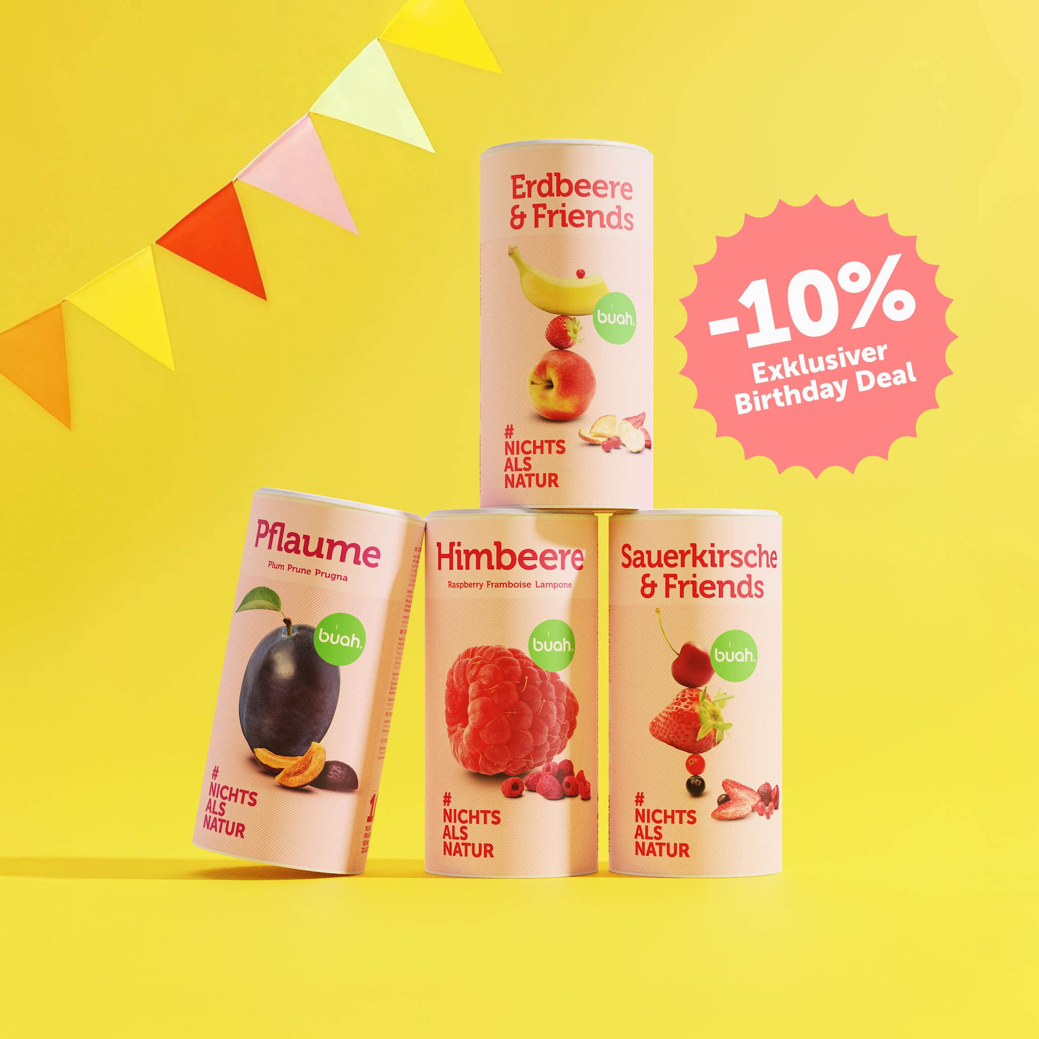 buah Birthday Set mit buah gefriergetrockneter Pflaume, Himbeere, Sauerkirsche & Friends und Erdbeere & Friends vor gelbem Hintergrund mit bunten Girlanden im Hintergrund, 10% Badge im Bild