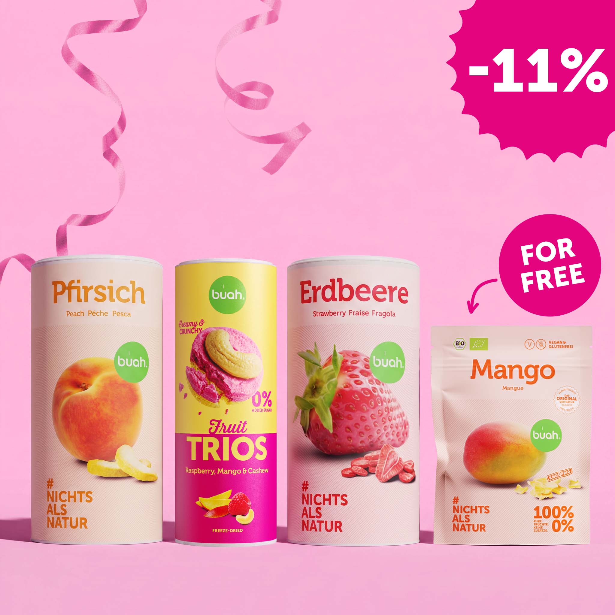 Drei große buah Dosen (Pfirsich, Fruit TRIOS Raspberry-Mango-Cashew und Erdbeere) stehen neben einem kleinen Beutel Mango vor einem pinken Hintergrund mit rosa Luftschlangen. Oben rechts ist ein gezackter Badge mit „-11%“, über dem Beutel steht in einer weißen Blase „FOR FREE“.